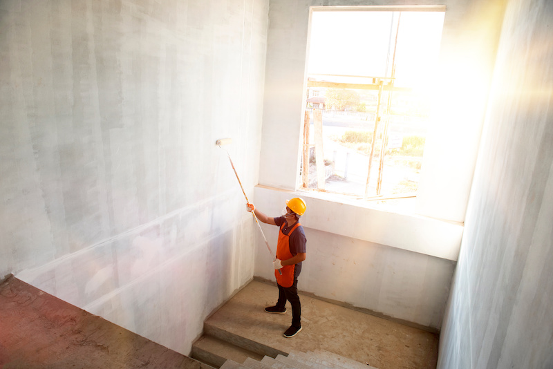 contractor with safety hat painting room